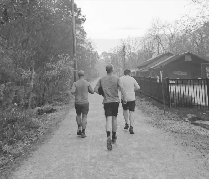 Three runners heading down the trail at sunrise